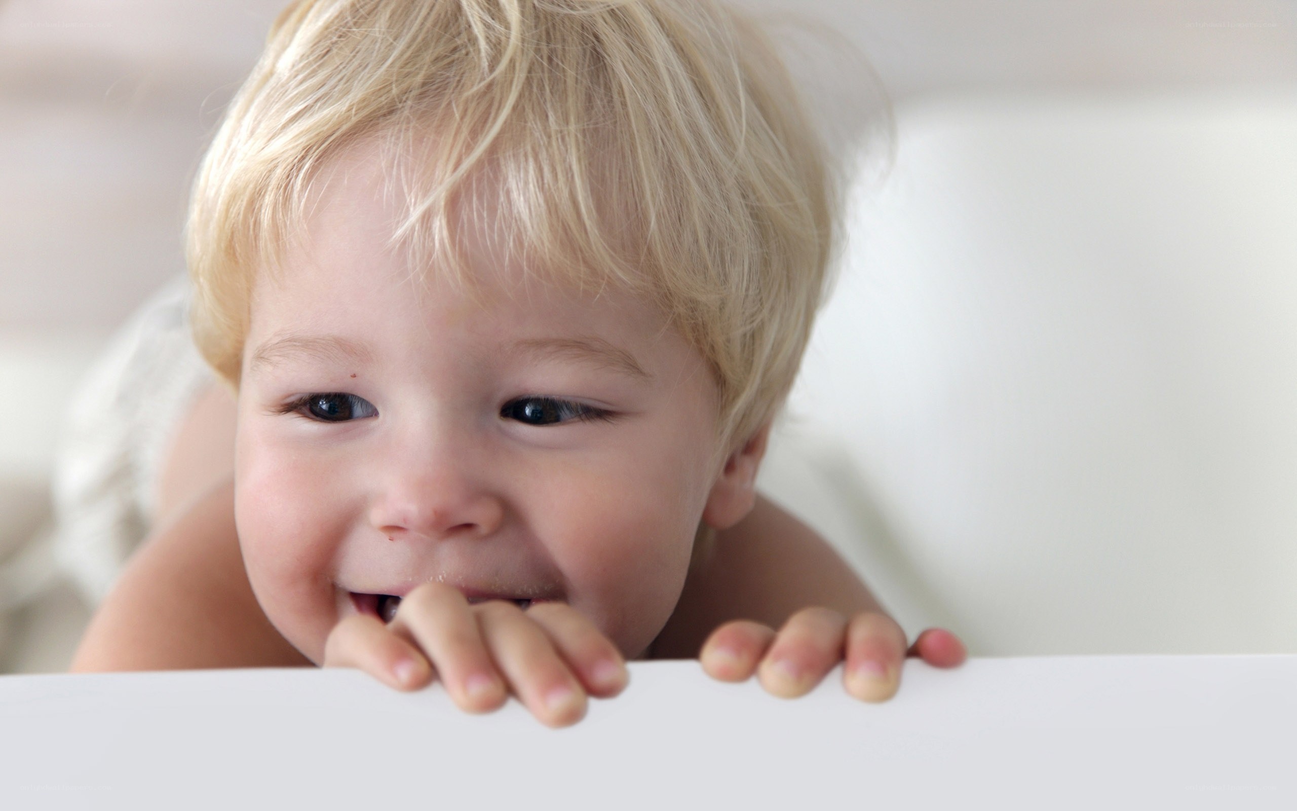 happy baby peeking over edge