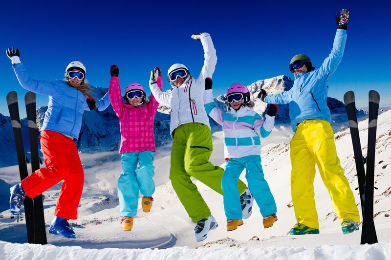 Happy skiers jumping on mountain