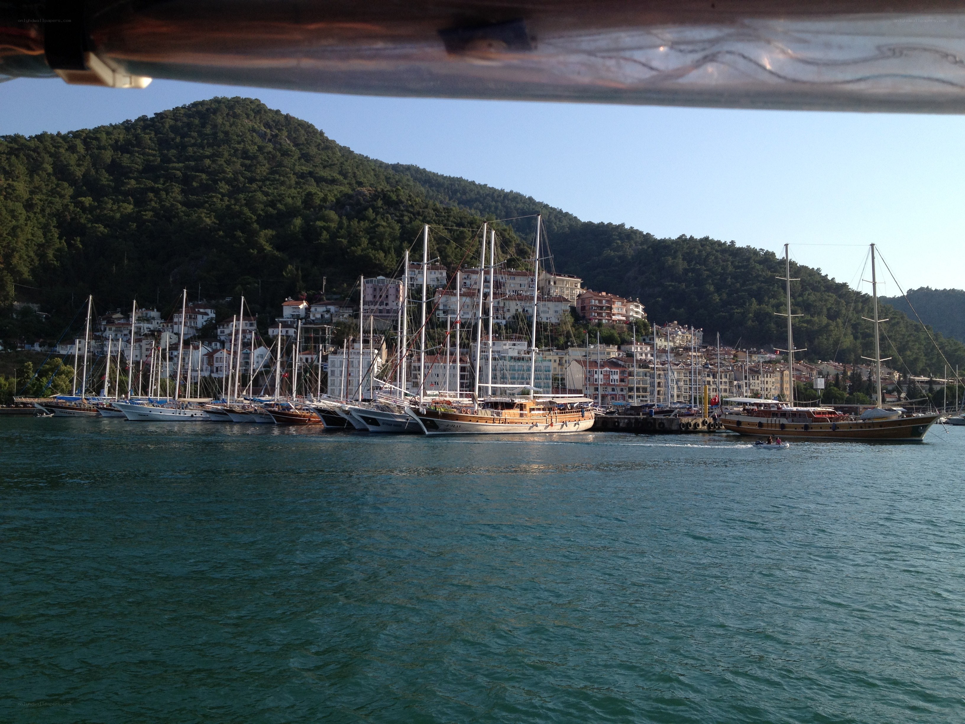 harbor with sailboats and hillside town