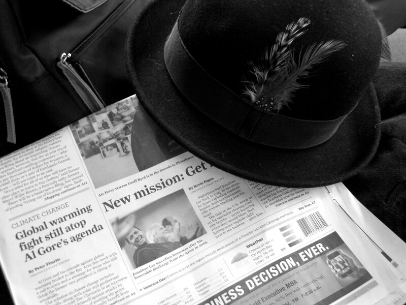 Hat on newspaper with feather