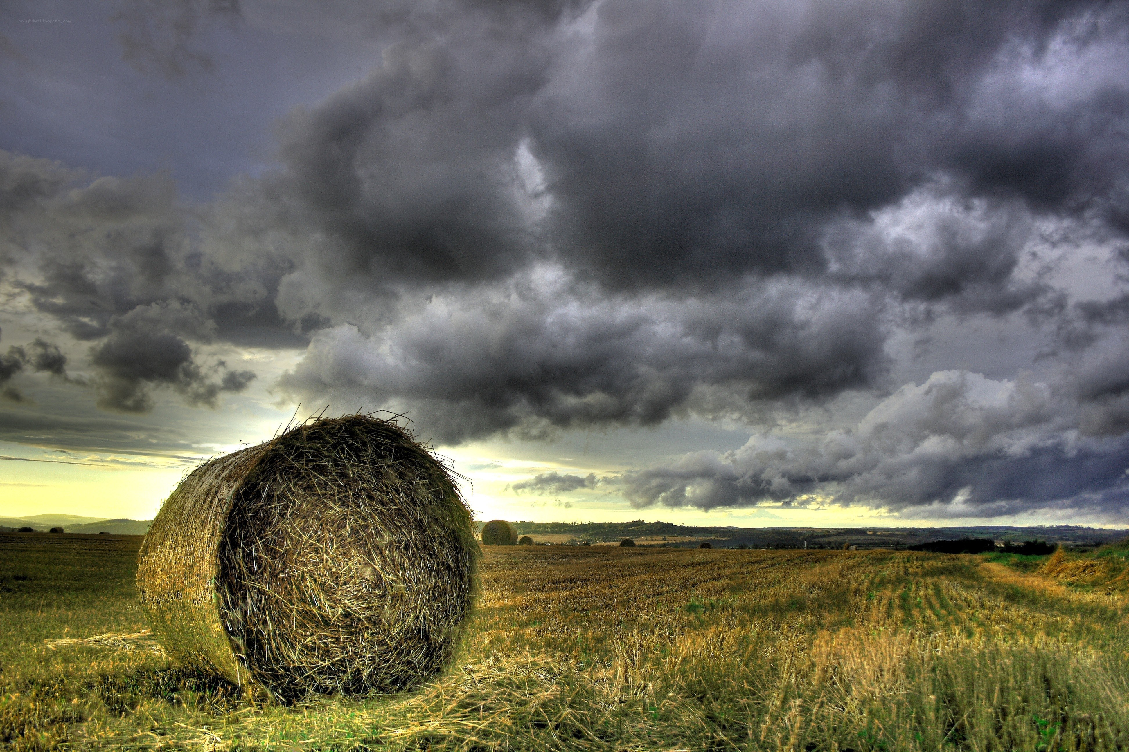 Hay bale under stormy sky