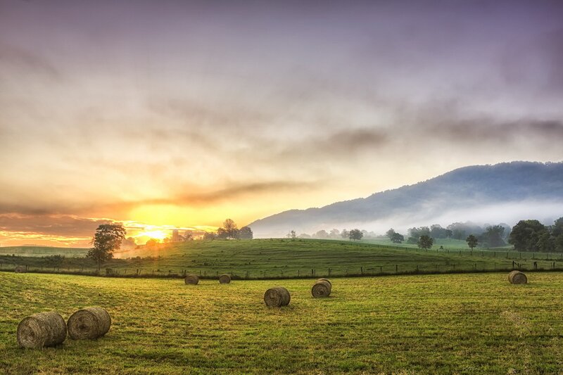Hay bales at sunrise in a valley