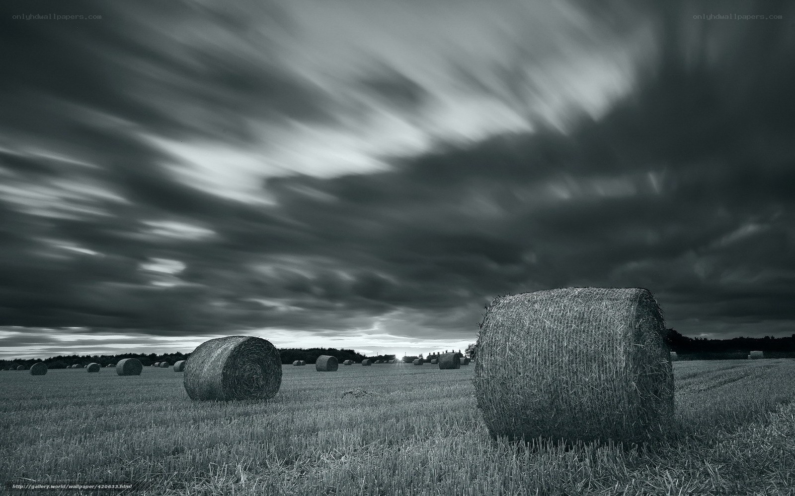 Hay bales under stormy sky