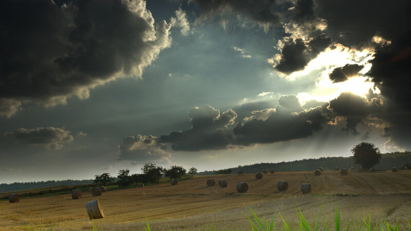 Hay bales under stormy sky