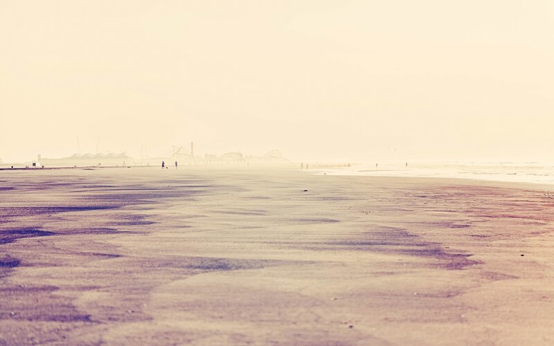 Hazy beach with distant pier