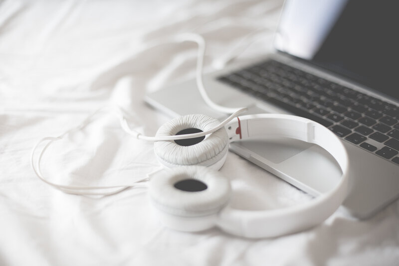 headphones and laptop on bed
