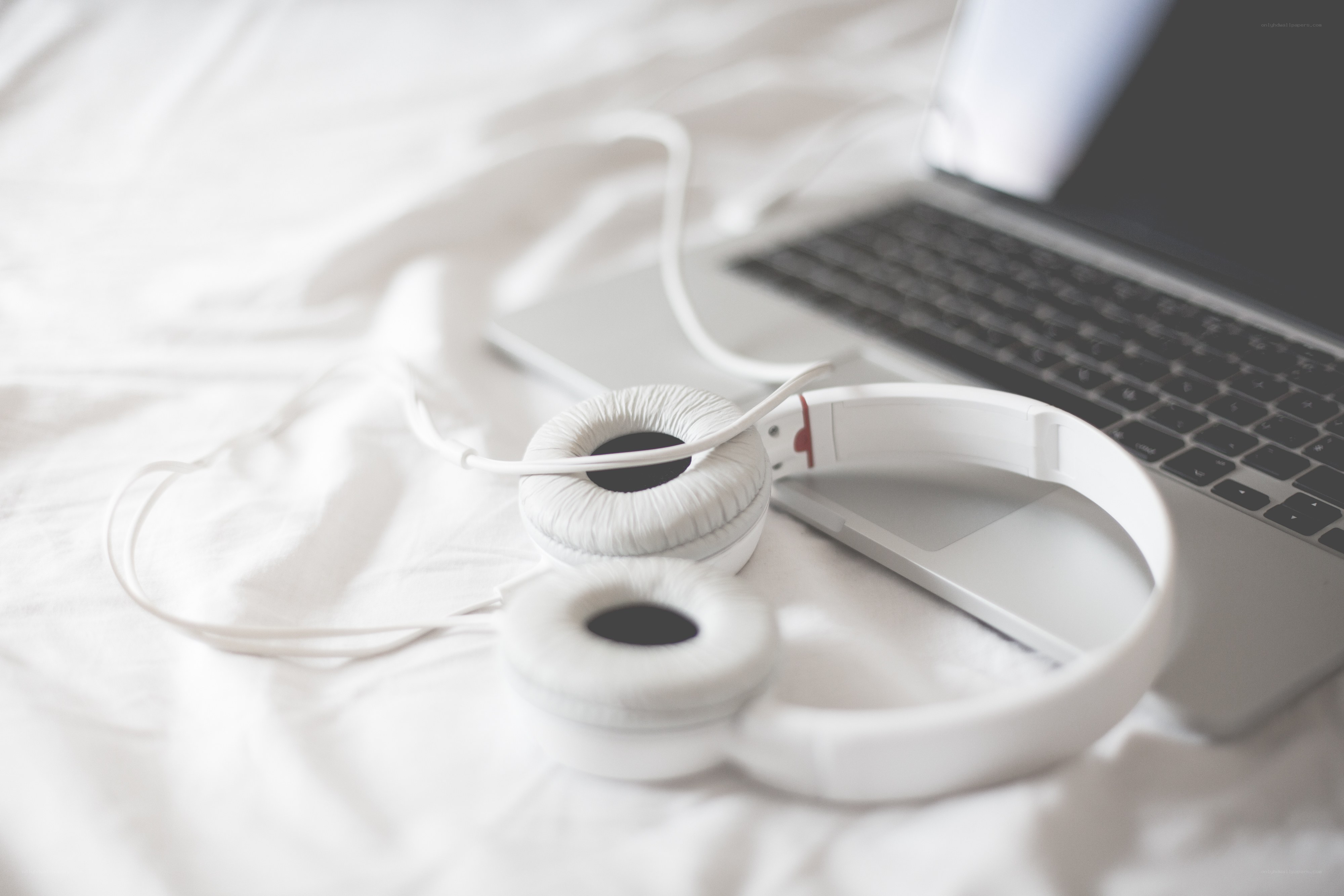 headphones and laptop on bed