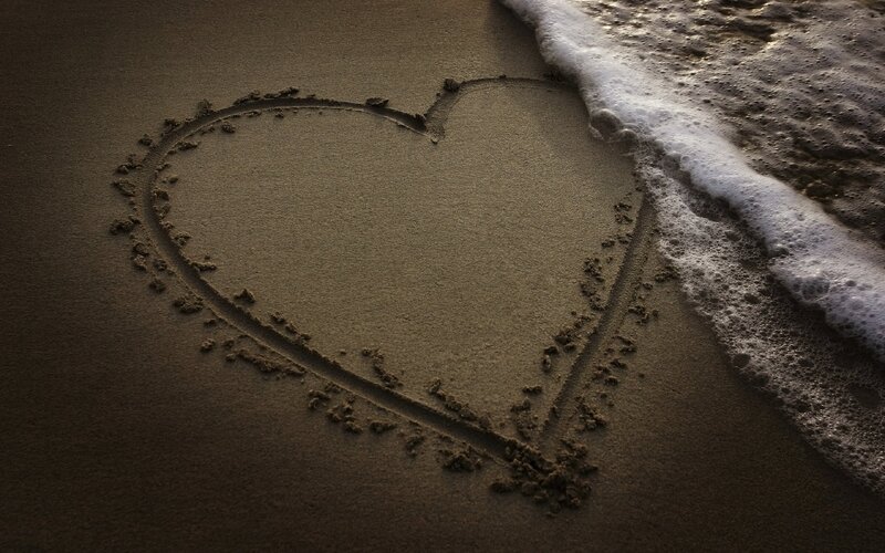 heart drawn in sand at beach