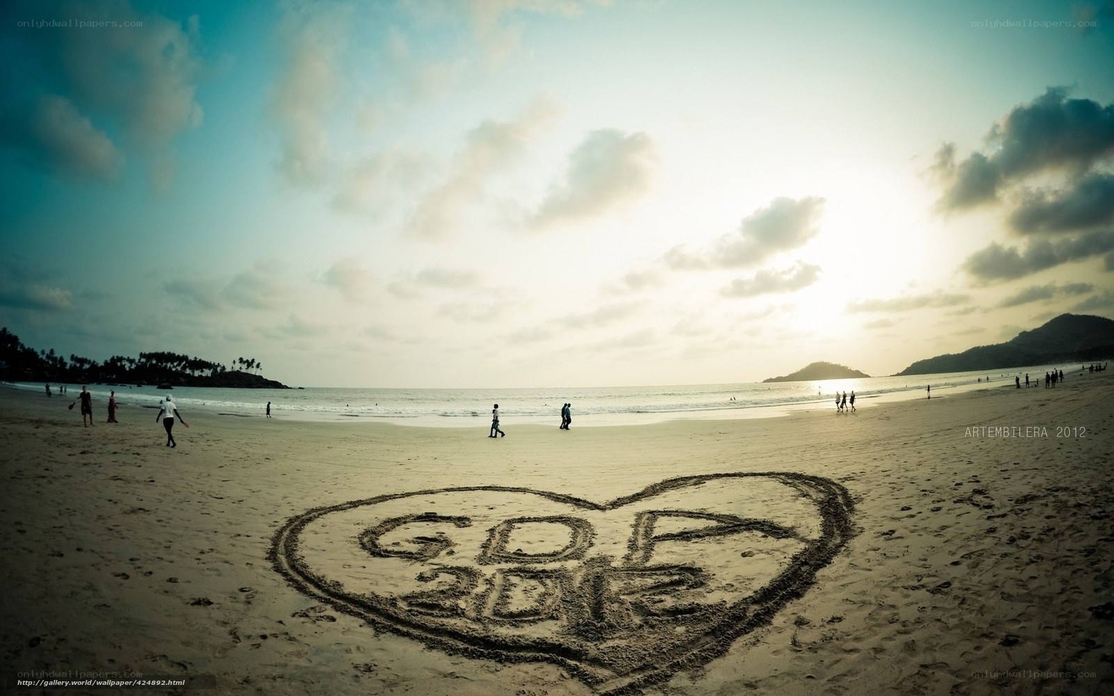 Heart drawn on beach at sunset