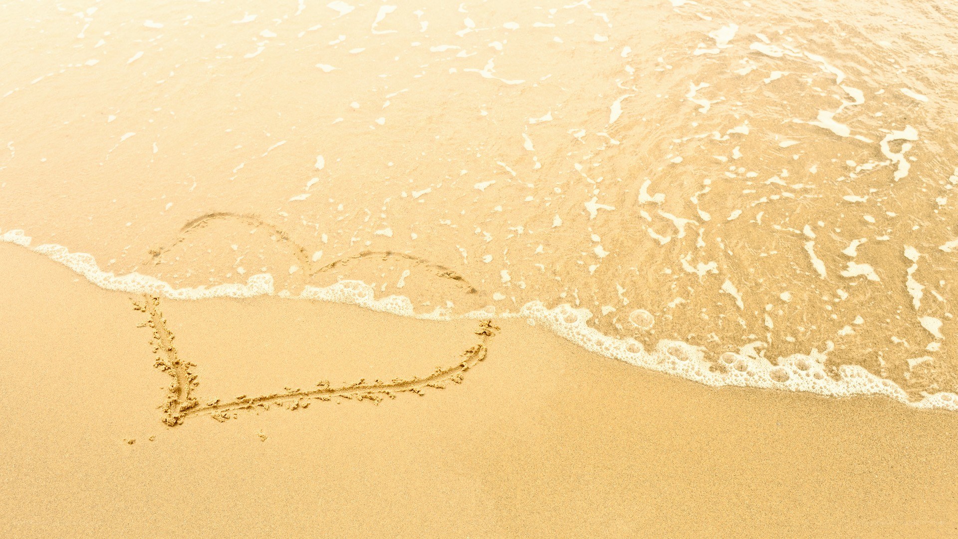 heart drawn on beach sand
