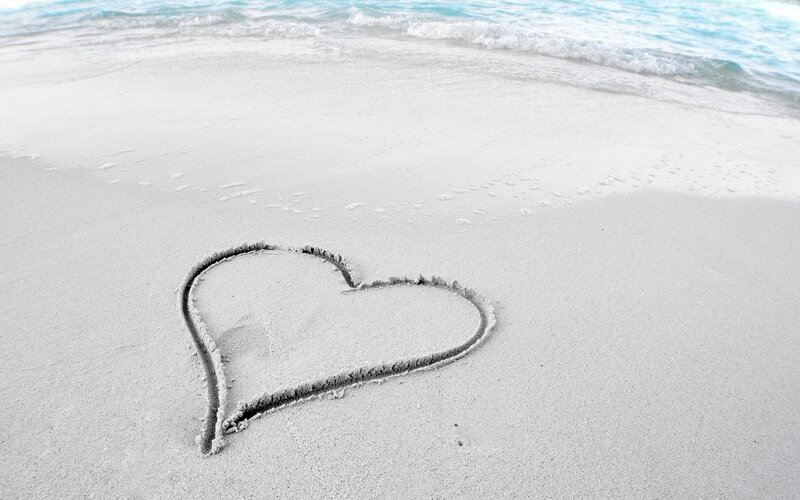 heart drawn on sandy beach