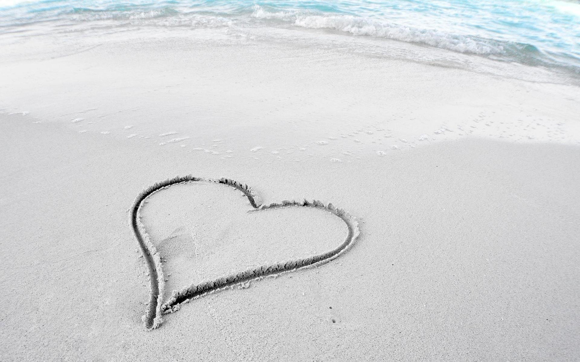 heart drawn on sandy beach