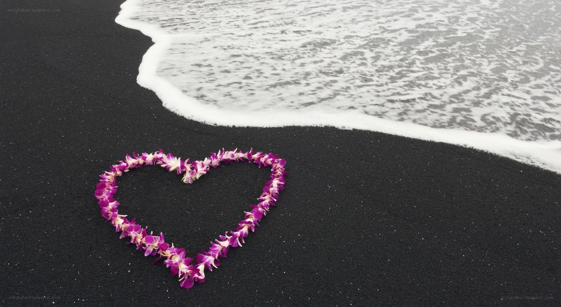 Heart of flowers on black sand