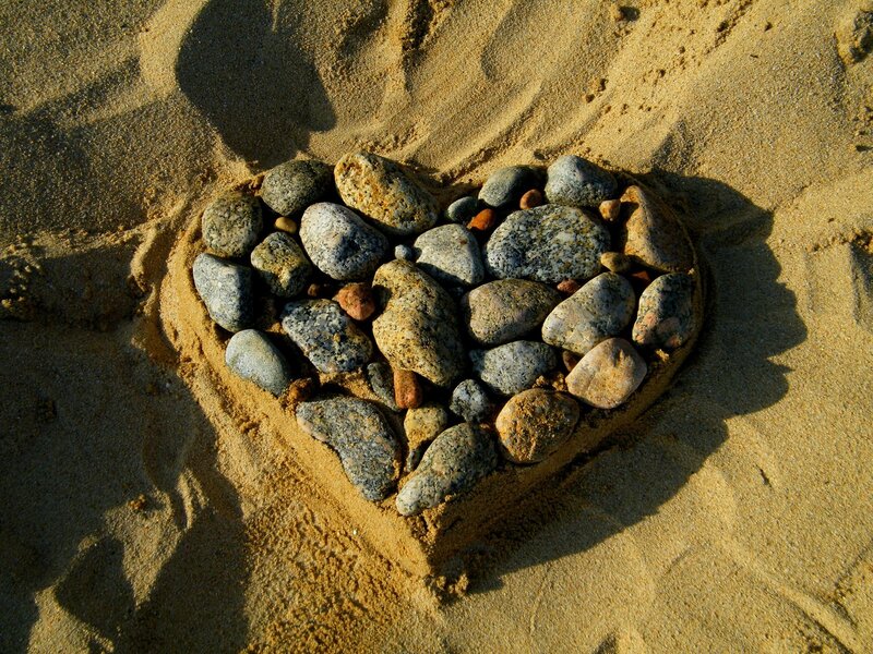 Heart shape made of stones on sand
