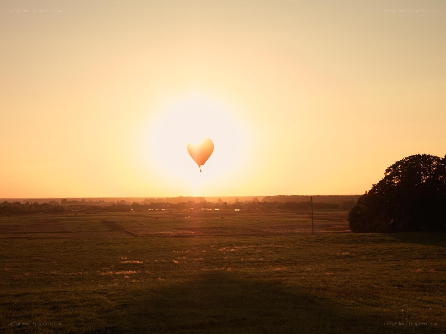 Heart-shaped balloon at sunset