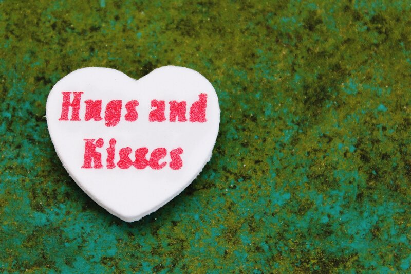 heart-shaped candy with hugs and kisses