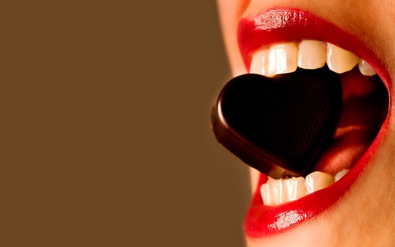 heart-shaped chocolate in mouth