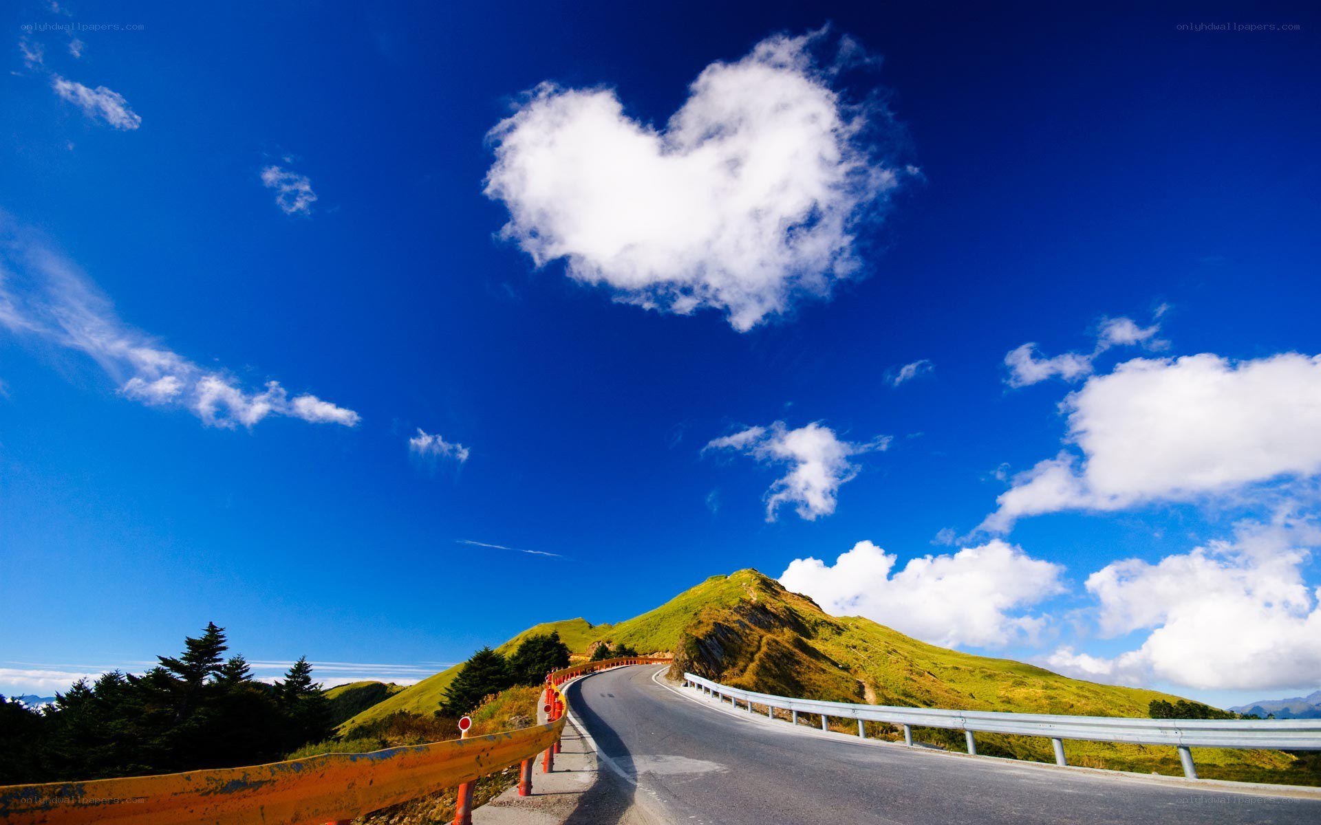 Heart-shaped cloud over mountain road