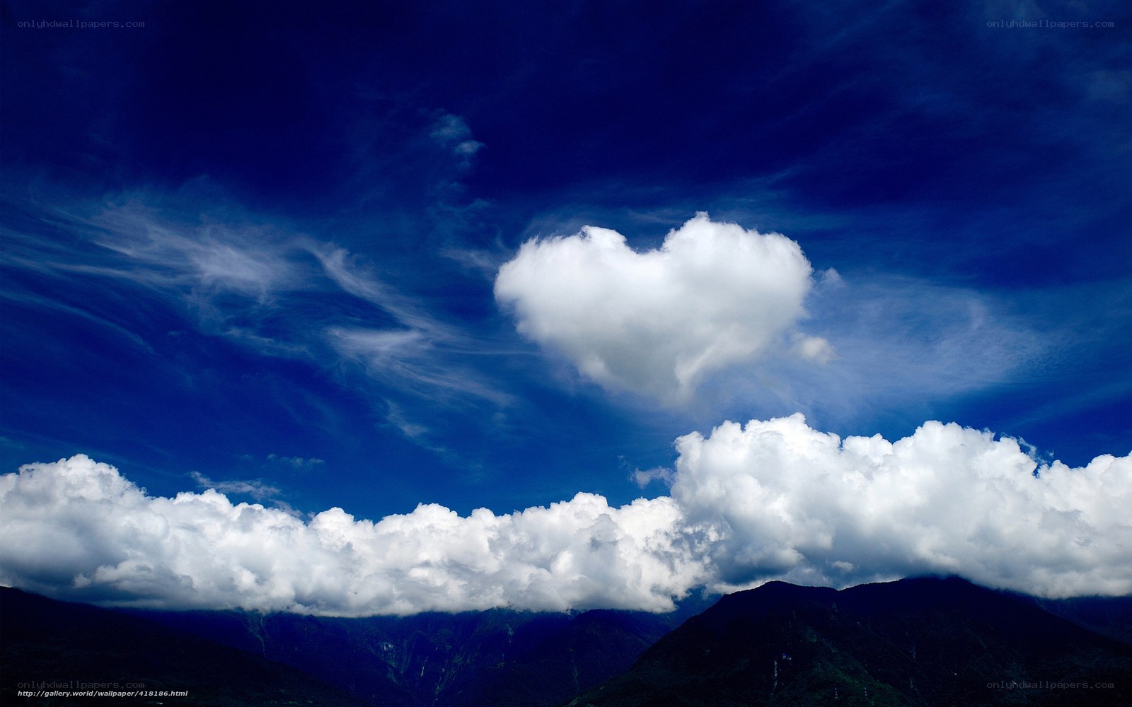 Heart-shaped cloud over mountains