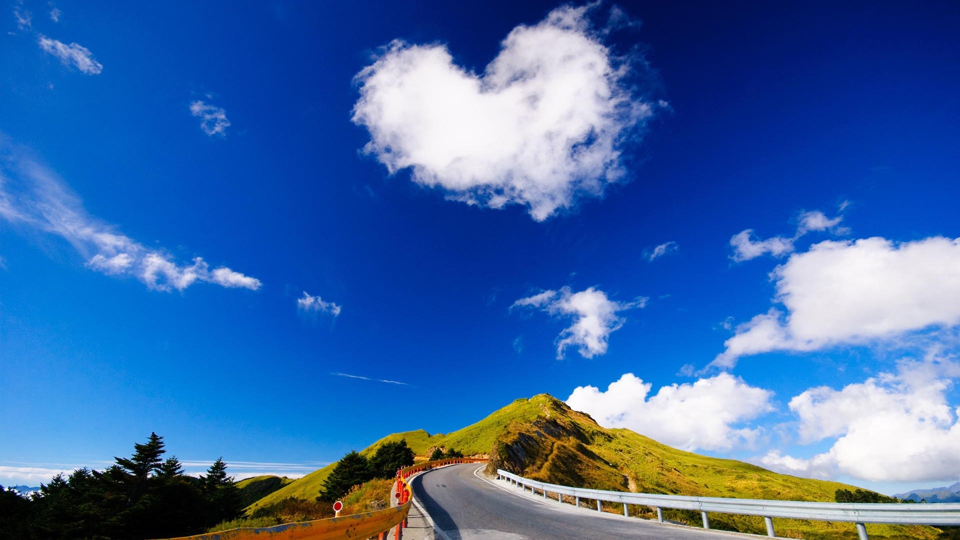 Heart-shaped cloud over winding road