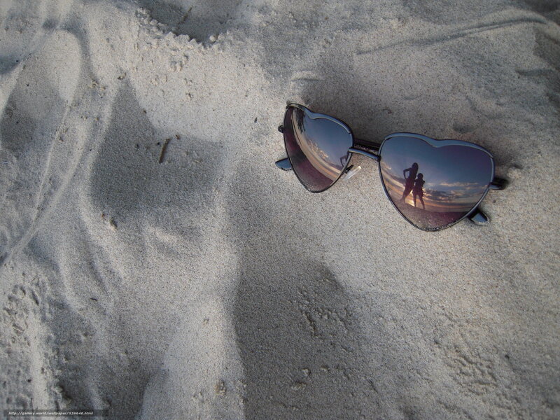 Heart-shaped sunglasses on sand
