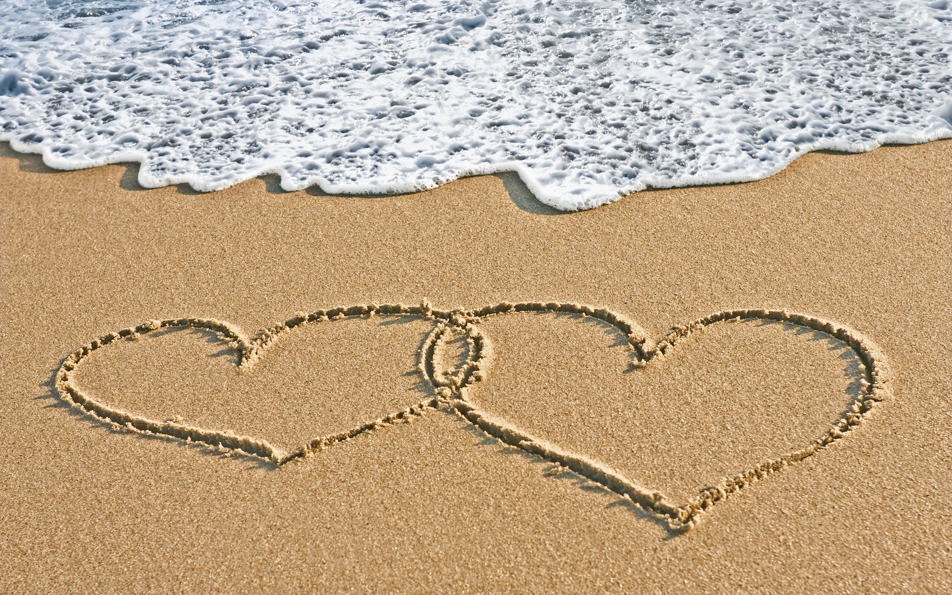 hearts drawn on beach sand