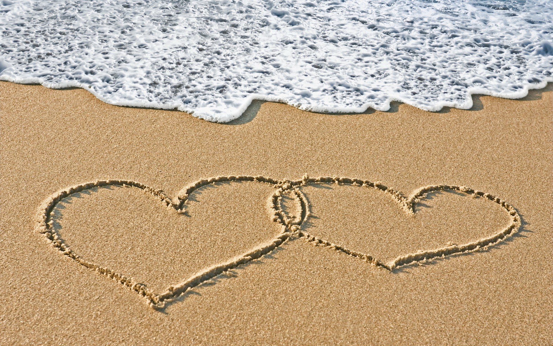 hearts drawn on beach sand
