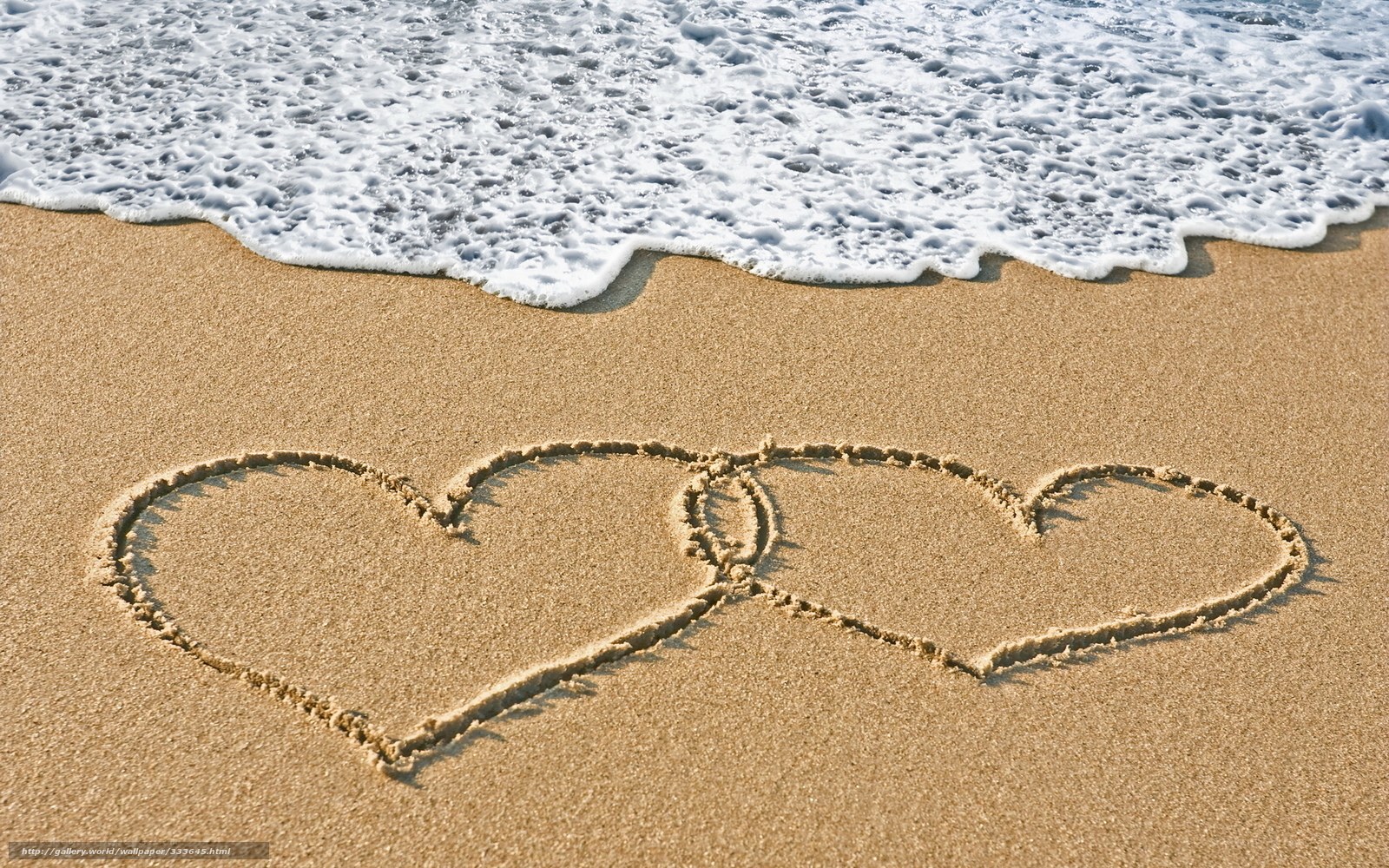 Hearts drawn on beach sand