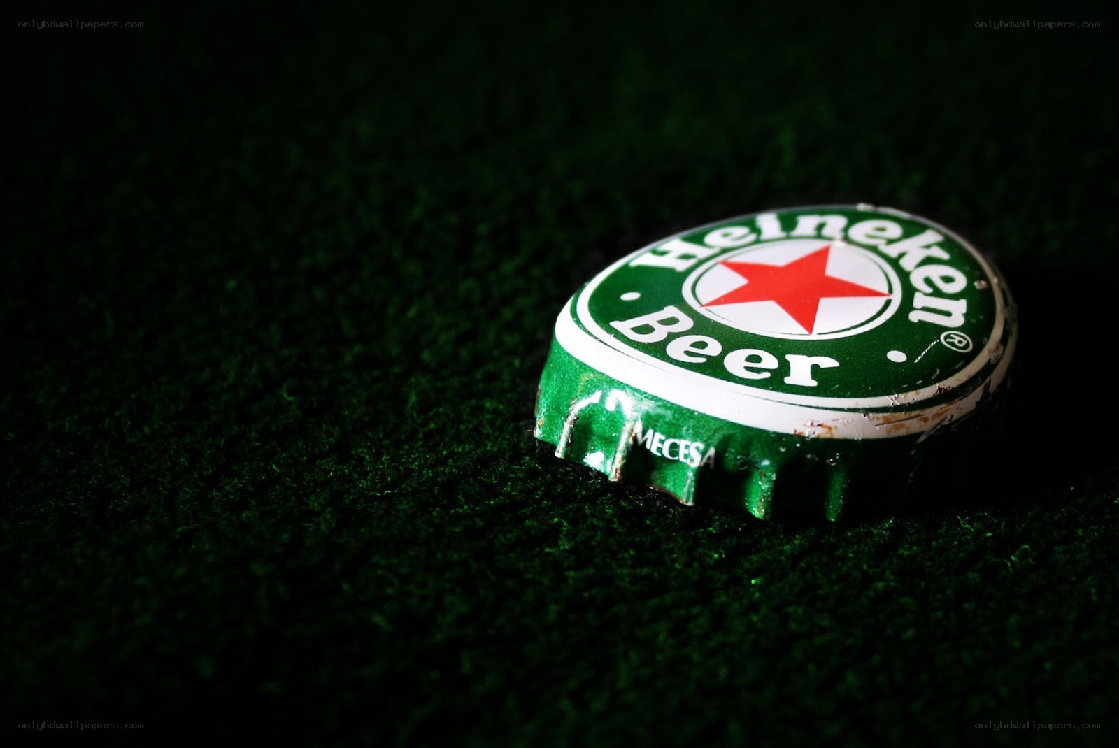 Heineken bottle cap on green surface