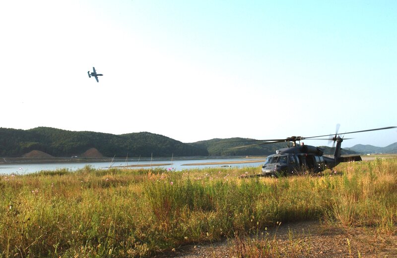 Helicopter and aircraft near a lake
