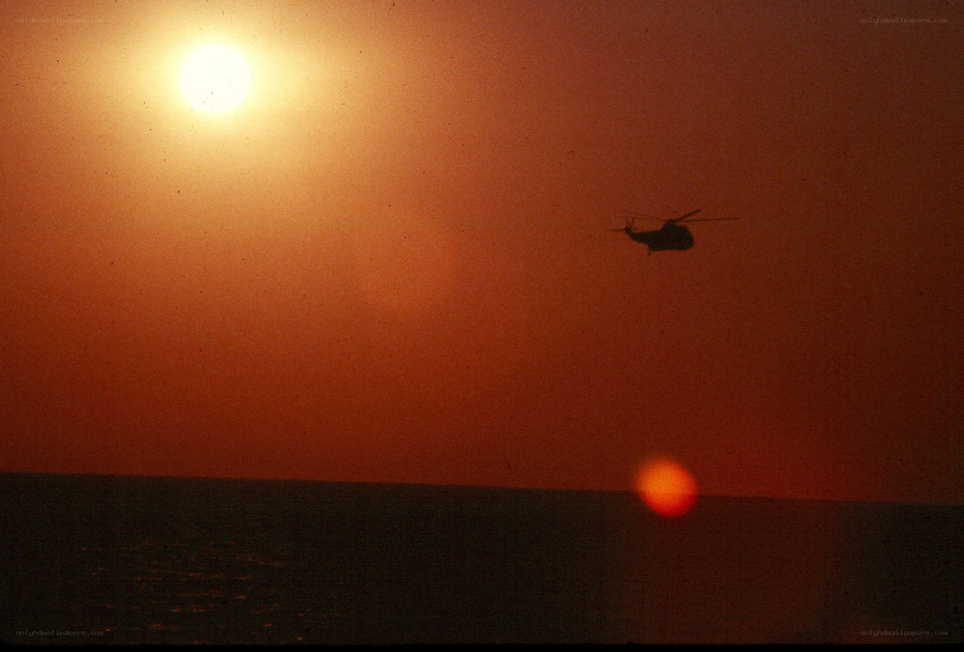 Helicopter at sunset over water