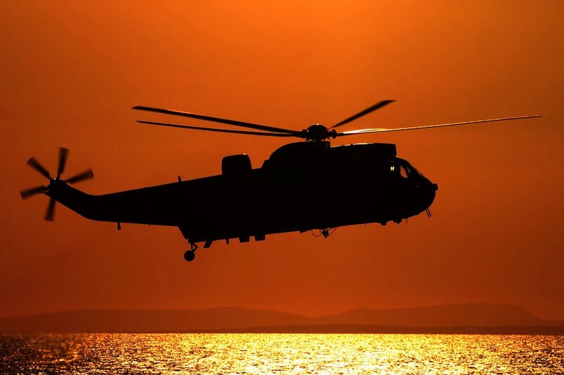 helicopter at sunset over water