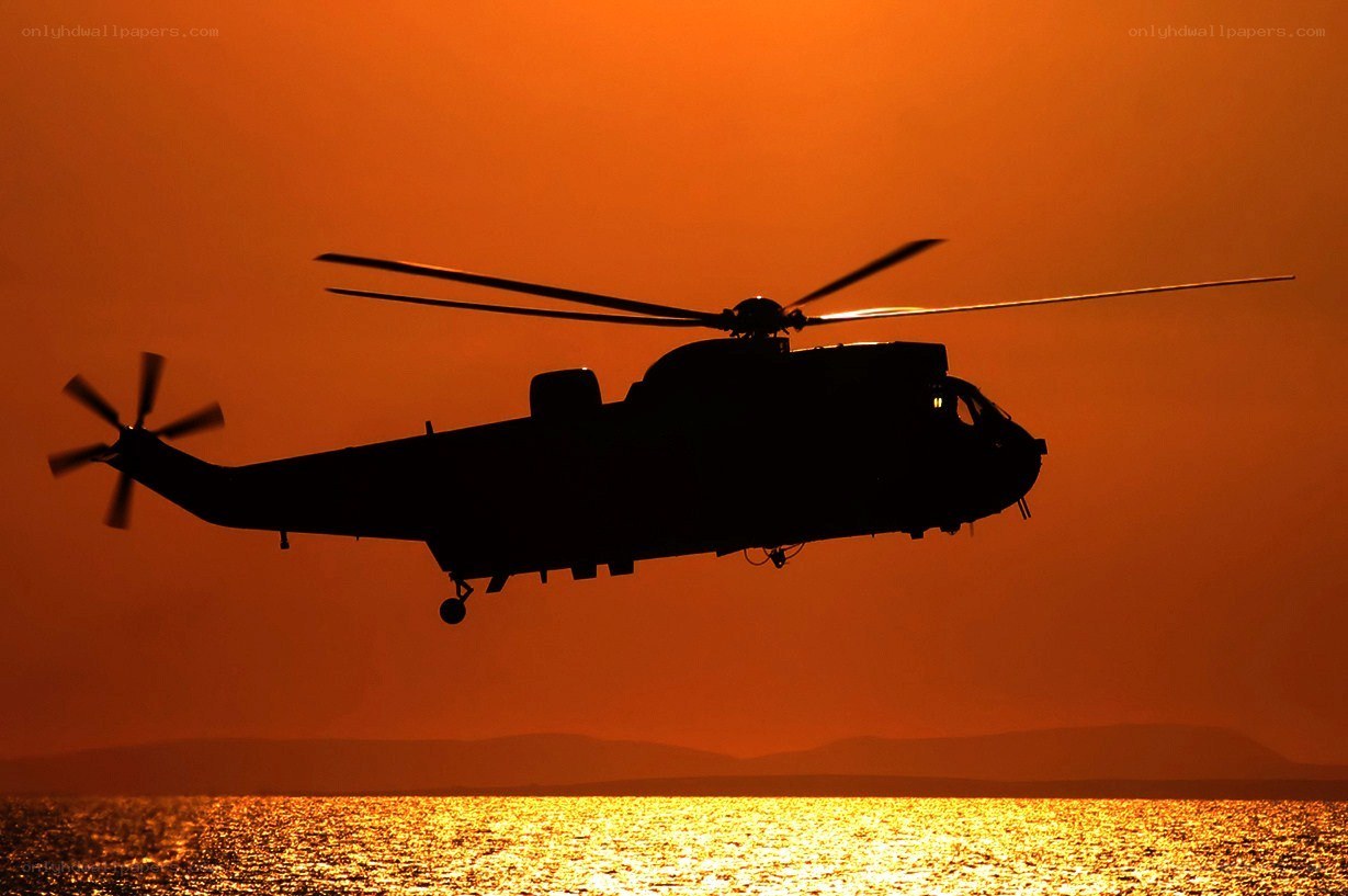 helicopter at sunset over water