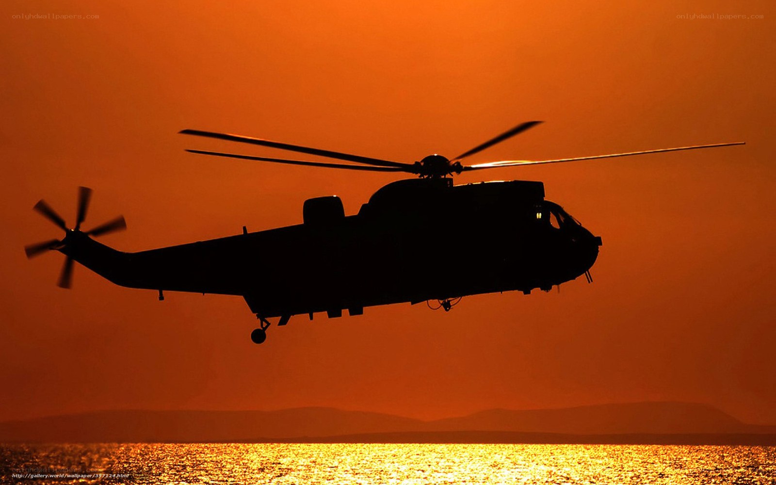 helicopter at sunset over water