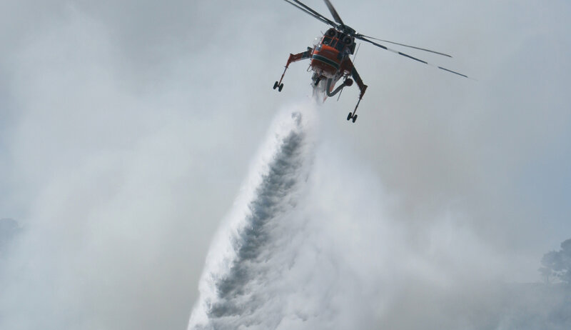 Helicopter dropping water on fire
