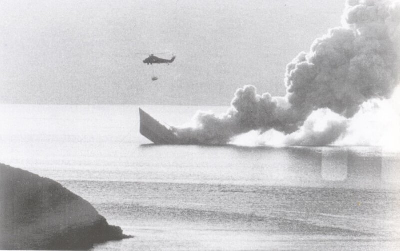 Helicopter drops water on burning ship