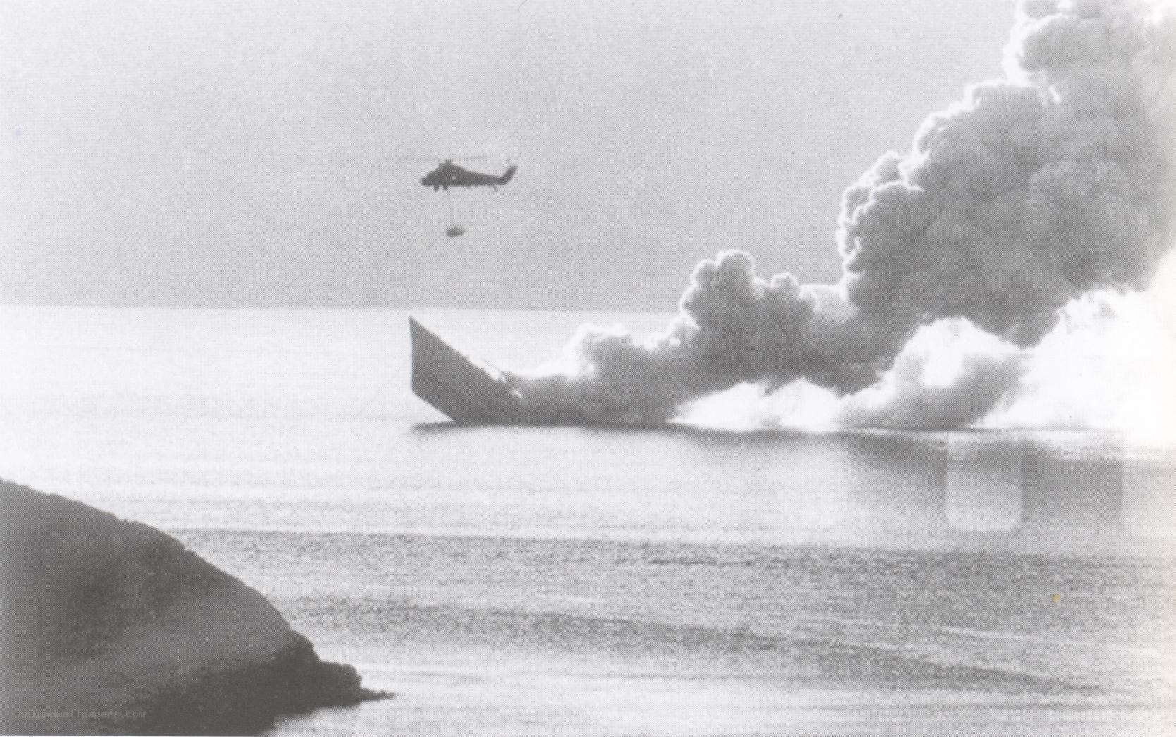 Helicopter drops water on burning ship