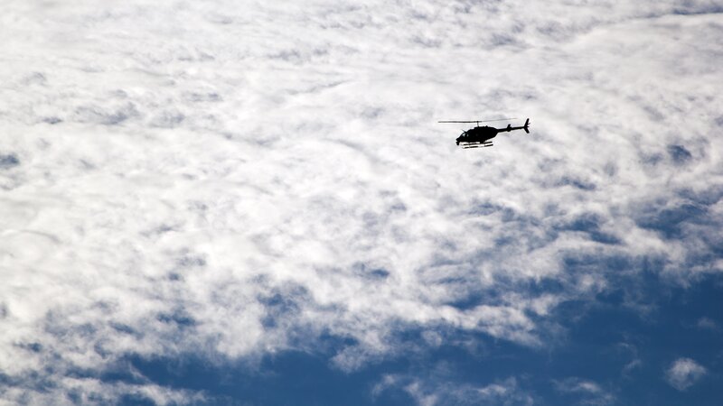Helicopter flying in cloudy sky
