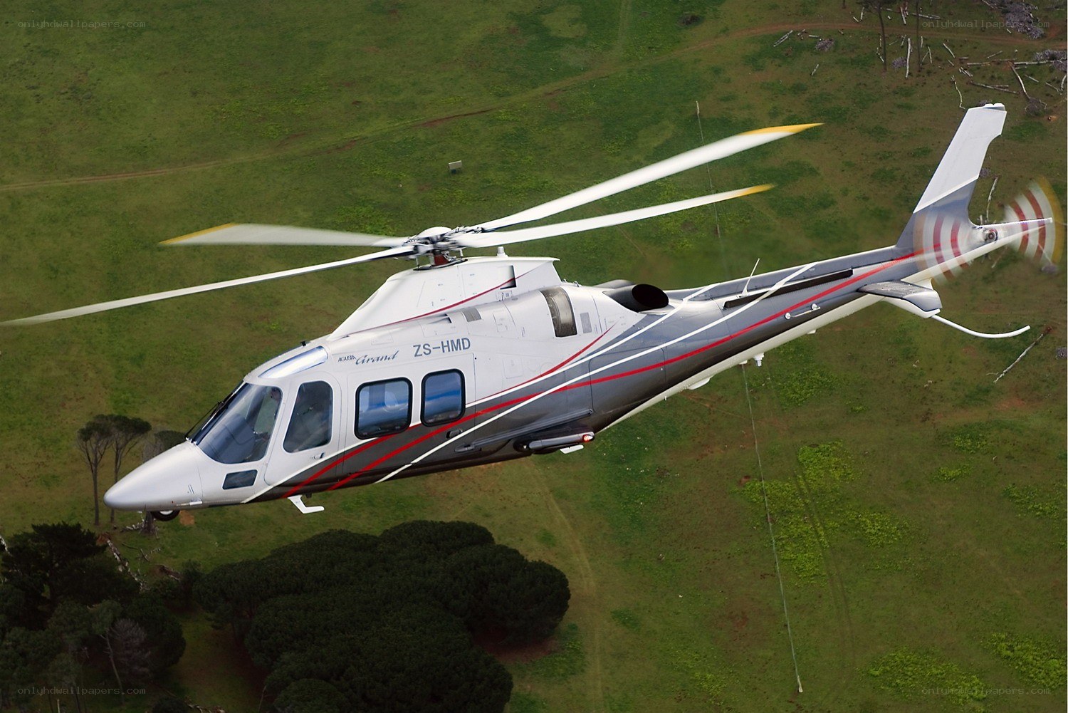 helicopter flying over green field