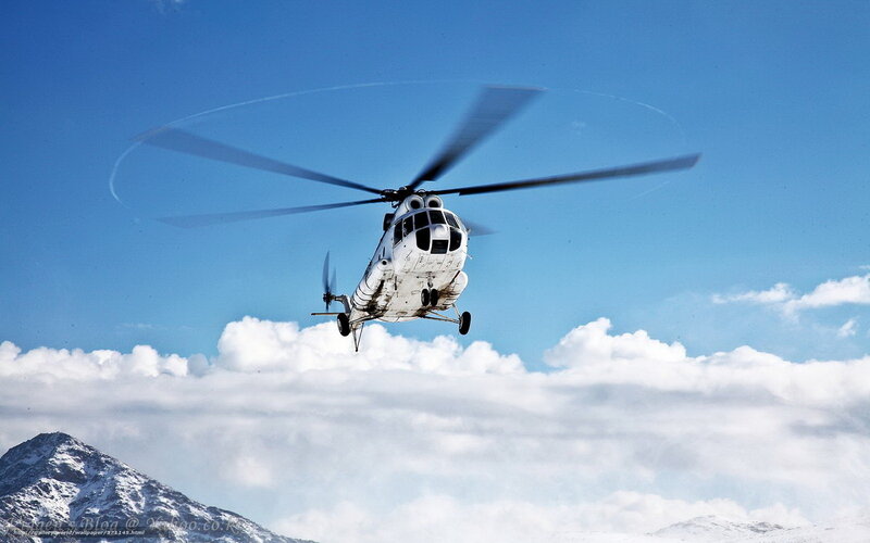 Helicopter flying over snowy mountains