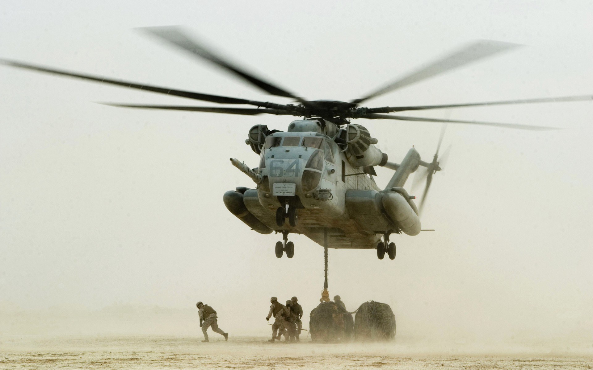 Helicopter lifting cargo in desert