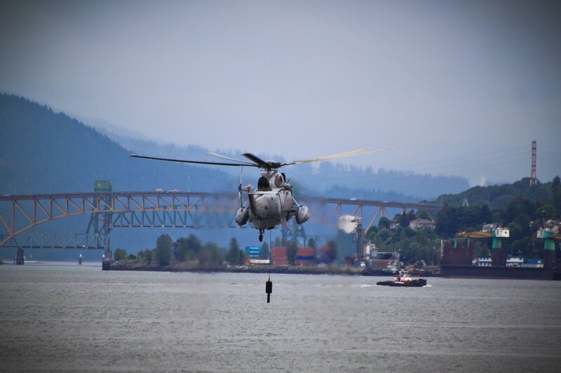 Helicopter lifting cargo over water