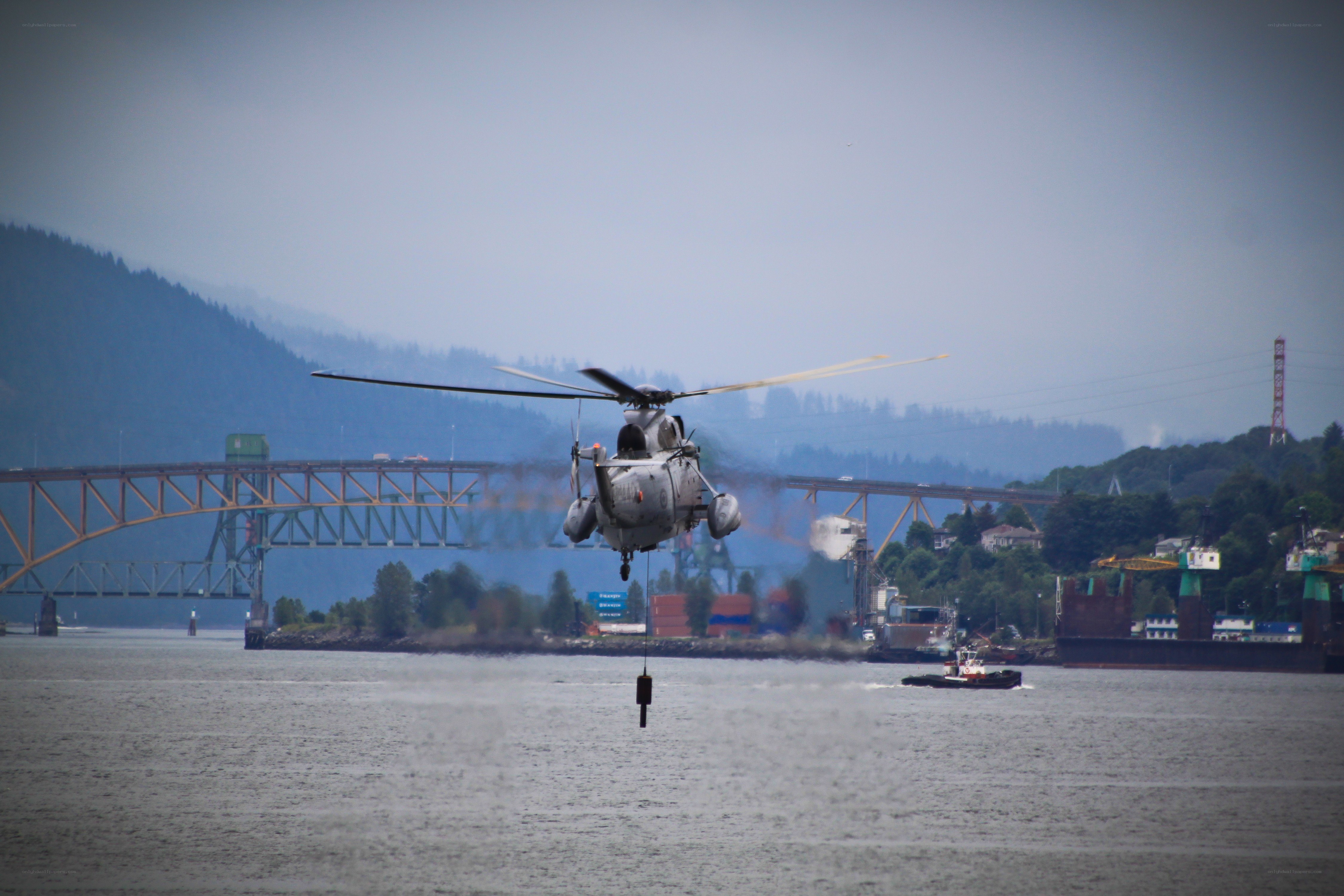 Helicopter lifting cargo over water