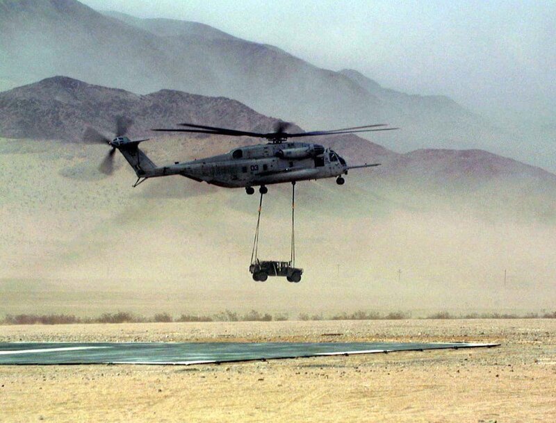 Helicopter lifting vehicle in desert