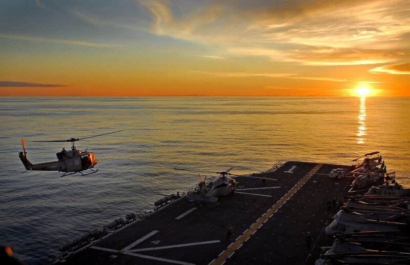 Helicopter on aircraft carrier at sunset