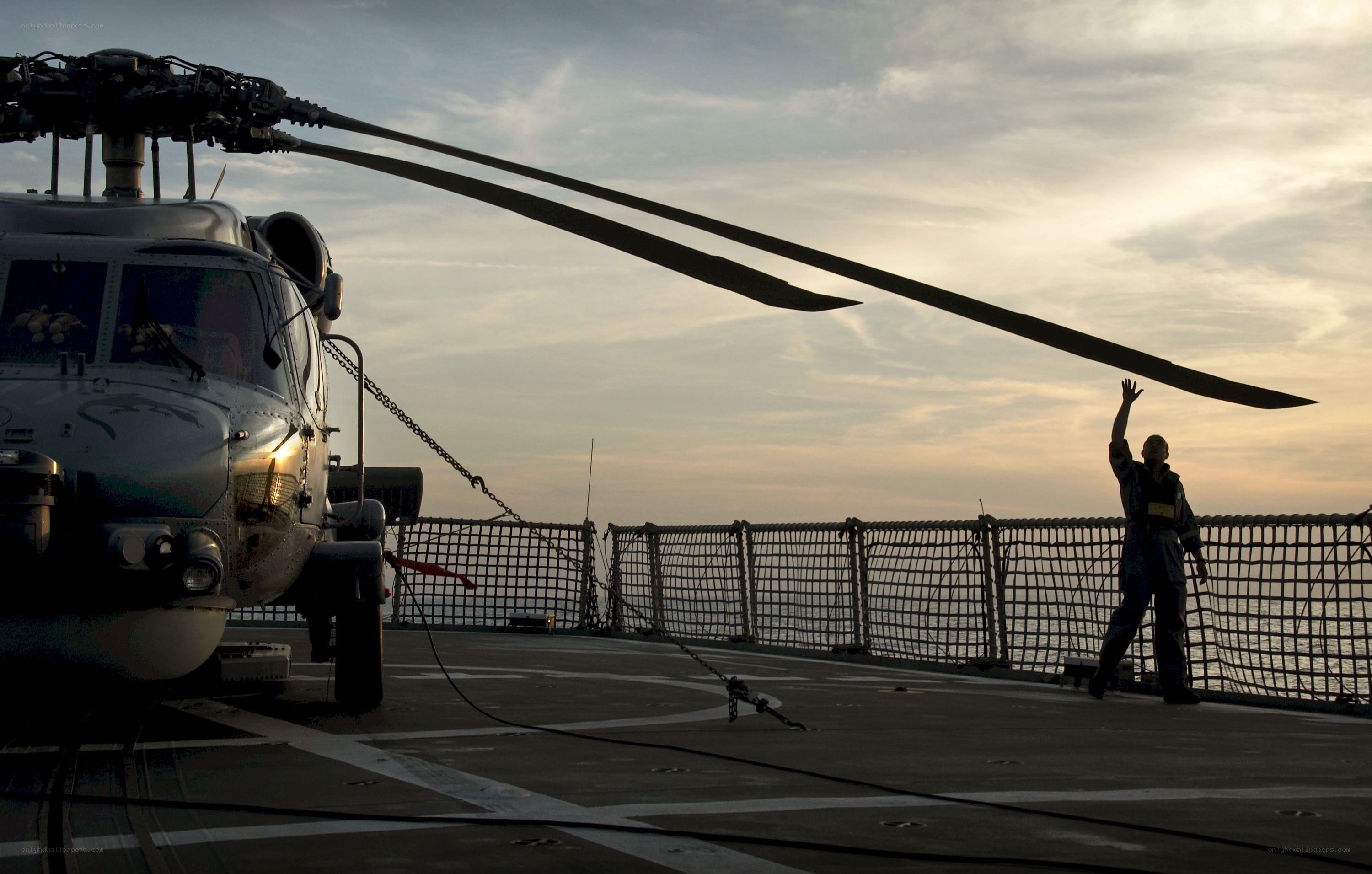 Helicopter on ship deck at sunset