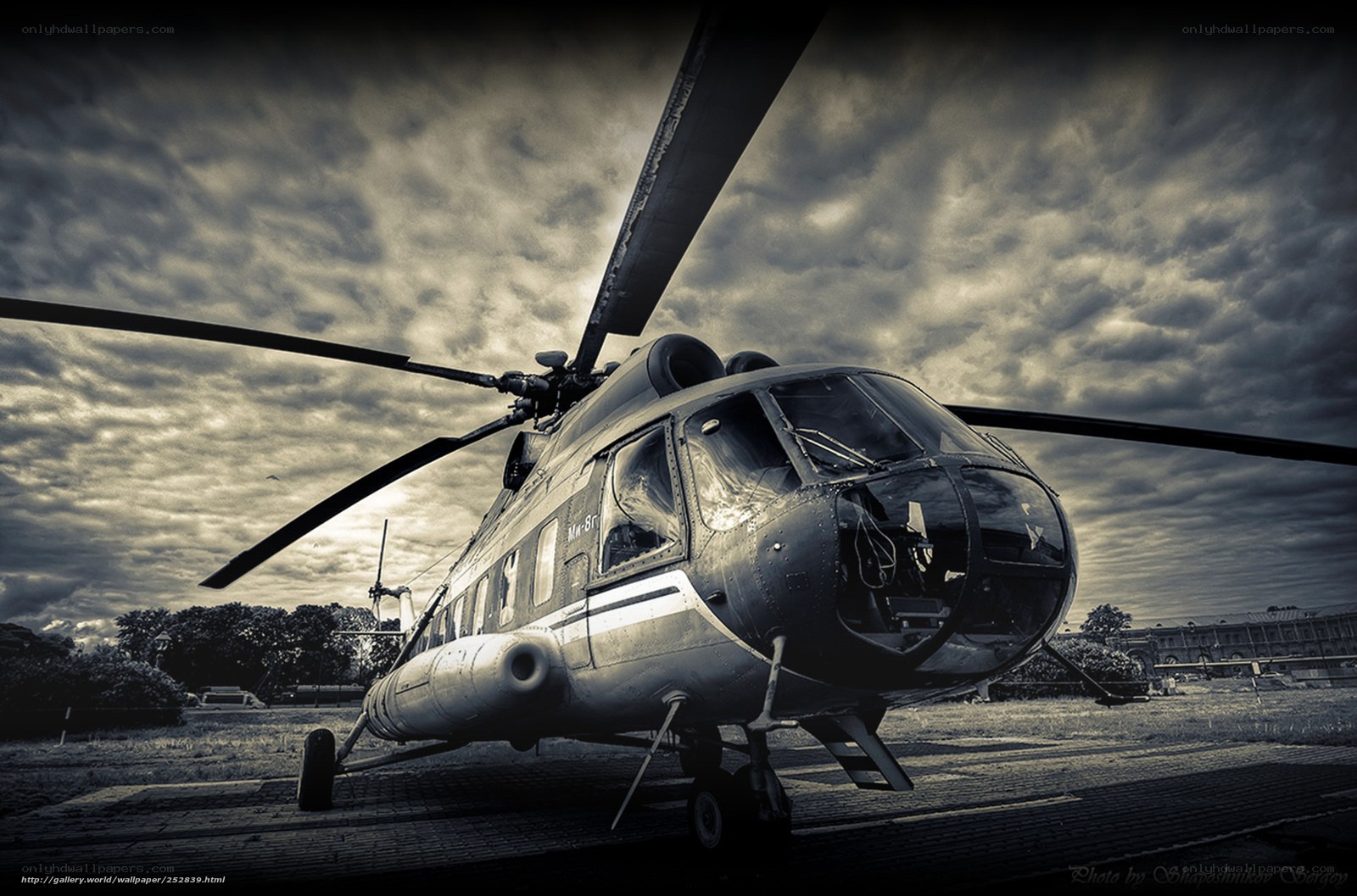 Helicopter on tarmac under cloudy sky