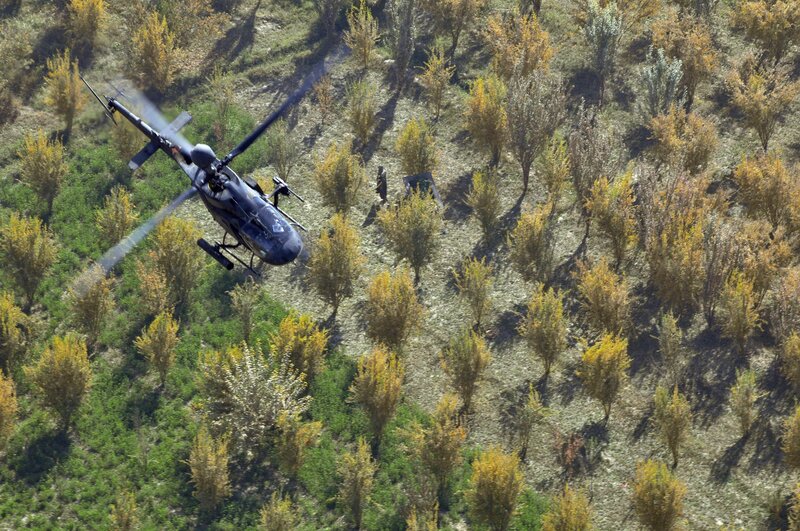 Helicopter over forested hillside