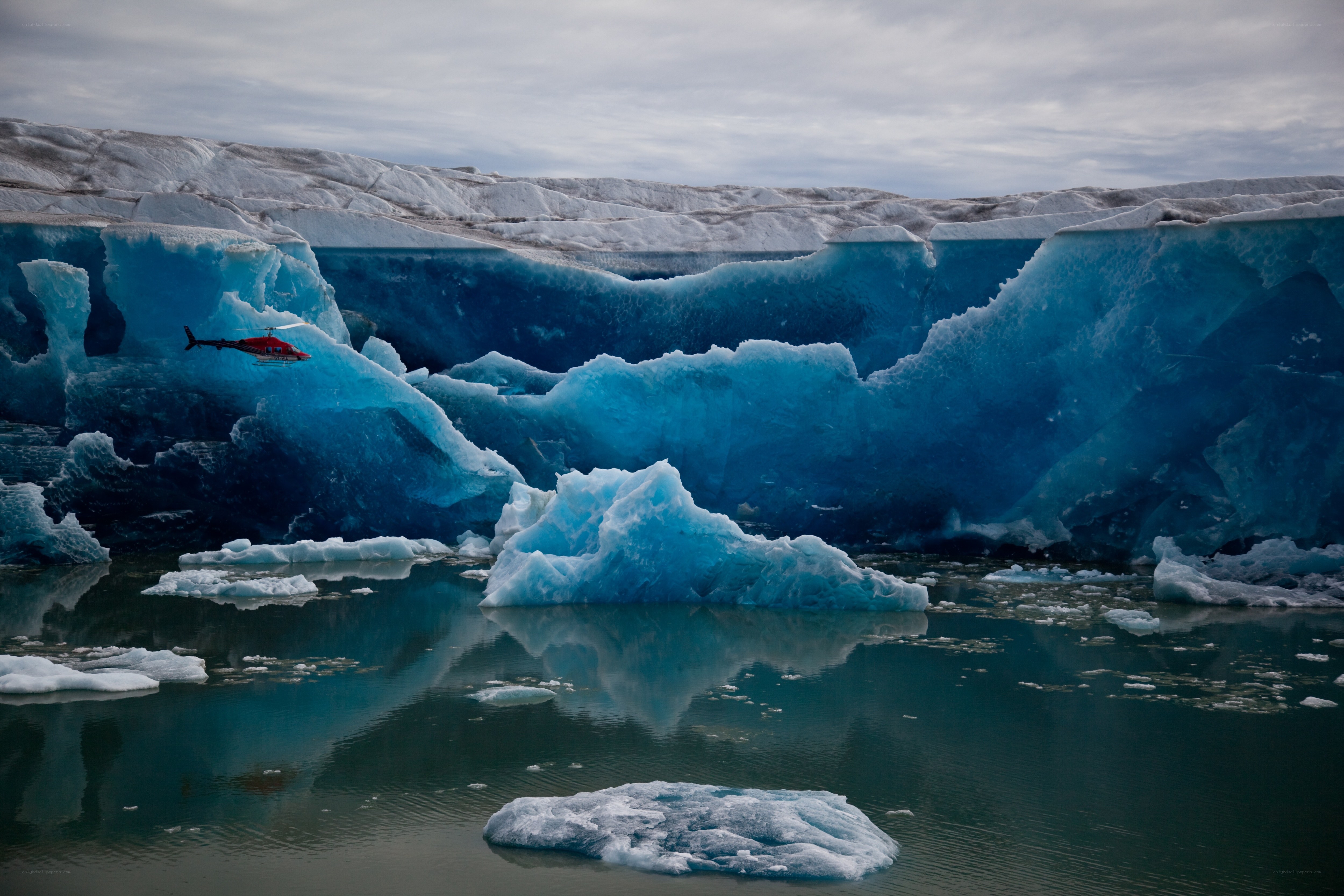 Helicopter over icebergs