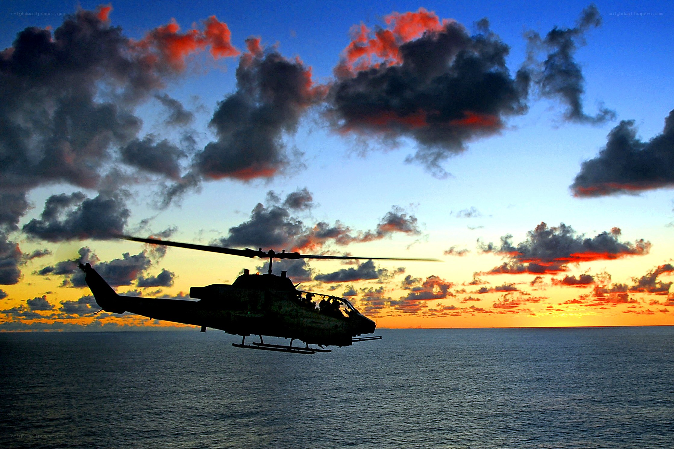 Helicopter over ocean at sunset